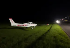A small plane making an emergency landing in a field beside the Grand Parkway