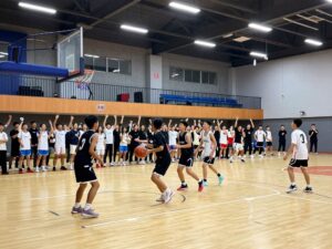 High school students playing basketball in a gym.