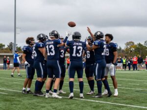 High school football players celebrating with a somber expression
