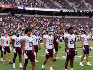 Texas A&M football players preparing for an all-star game in a vibrant stadium.