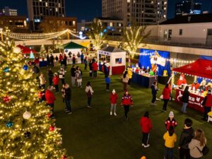 Families enjoying the festive atmosphere at Texas Winter Lights with twinkling lights in the background.