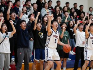 Fans cheering at a high school basketball game