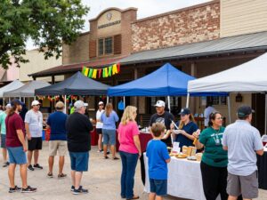 A lively community event with food booths and smiling residents in The Woodlands.