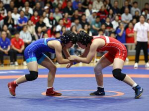 High school girls wrestling match with female athletes competing fiercely.