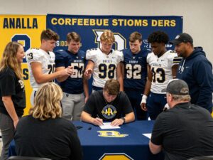 Young athletes celebrating their football commitments during a signing day event.